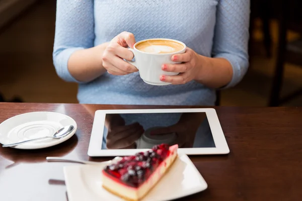 Close up of hands with coffee, tablet pc and cake — Stock Photo, Image