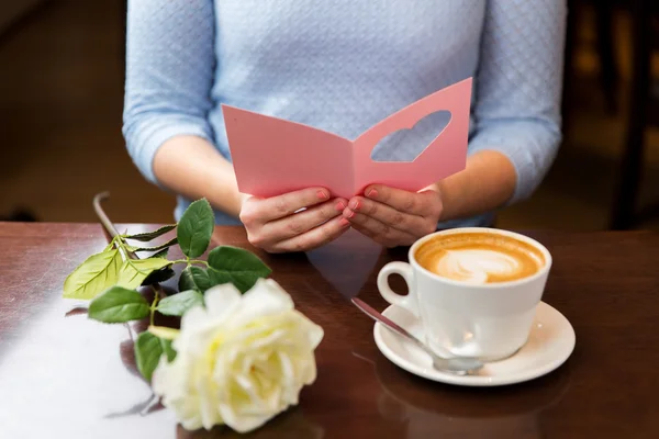 Primer plano de la mujer leyendo tarjeta de felicitación y café —  Fotos de Stock