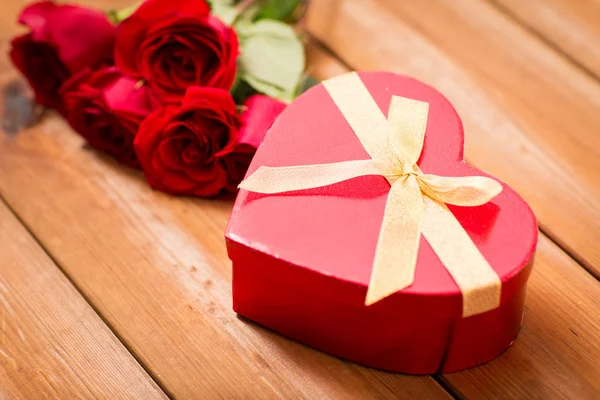 Close up of heart shaped gift box and red roses — Stock Photo, Image