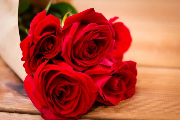 Gros plan de bouquet de roses rouges enveloppé dans du papier — Photo