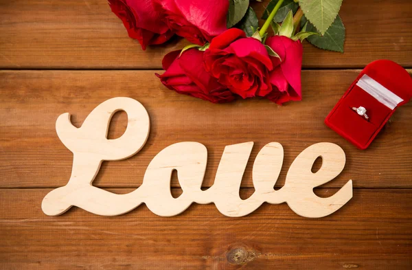 Close up of diamond ring, red roses and word love — Stock Photo, Image