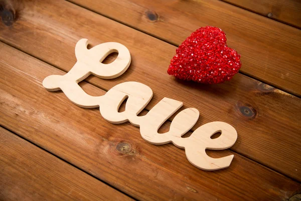 Close up de amor palavra com decoração coração vermelho — Fotografia de Stock