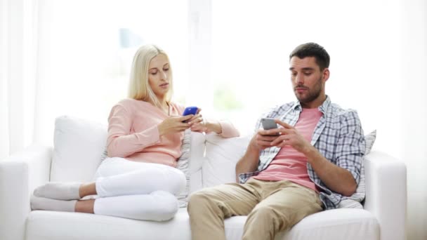 Paar mit Smartphone SMS zu Hause — Stockvideo