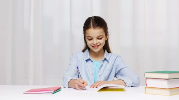 Chica de la escuela feliz con libros y bloc de notas en casa — Vídeos de Stock