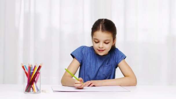 Щаслива дівчина малює кольоровими олівцями вдома — стокове відео