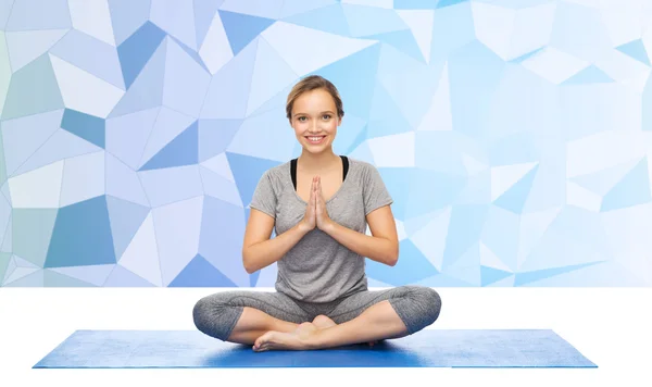 Vrouw maken van yoga meditatie in lotus pose op de mat — Stockfoto