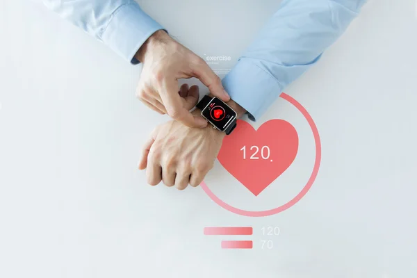 Close up of hands with heart icon on smart watch — Stock Photo, Image