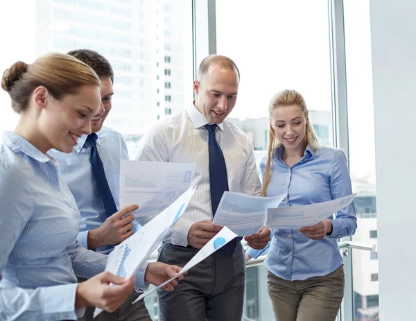 Glimlachende zakenmensen met documenten in office — Stockfoto