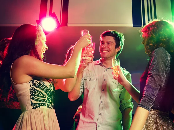 Amis souriants avec des verres de champagne en club — Photo