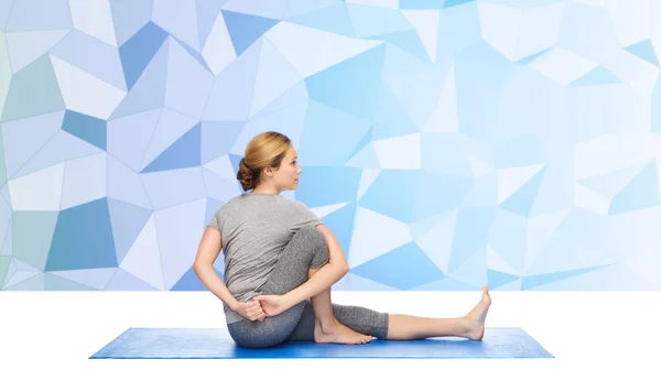 女人做瑜伽垫上的扭曲姿势 — 图库照片