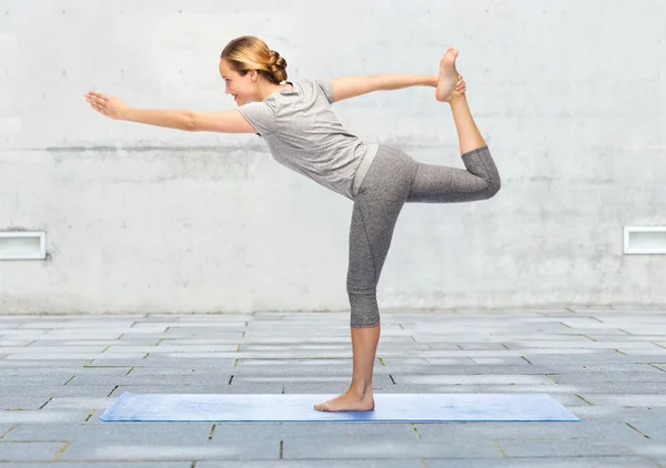 Vrouw maken yoga in heer van de dans pose op mat — Stockfoto