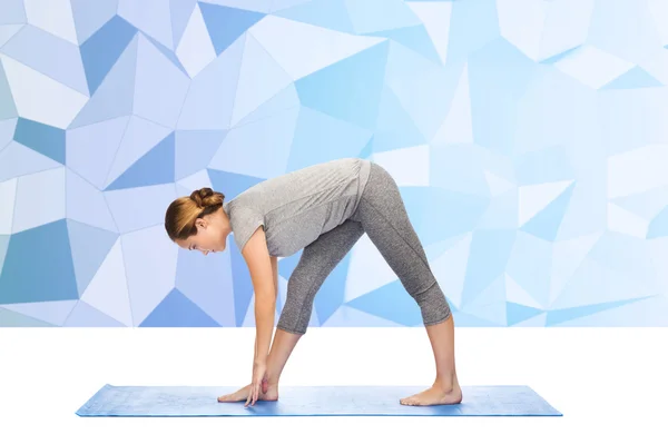 Žena dělat jógu intenzivní roztáhnout pozice na mat — Stock fotografie