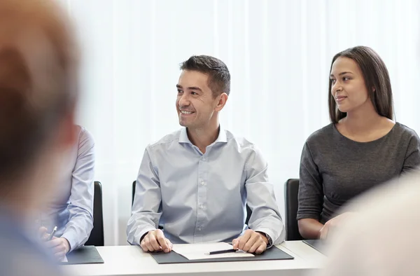 Grupo de empresários sorridentes reunidos no escritório — Fotografia de Stock