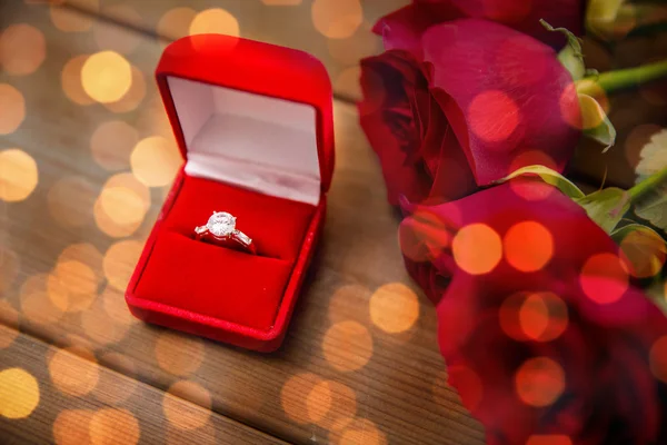 Nahaufnahme von Diamant-Verlobungsring und roten Rosen — Stockfoto