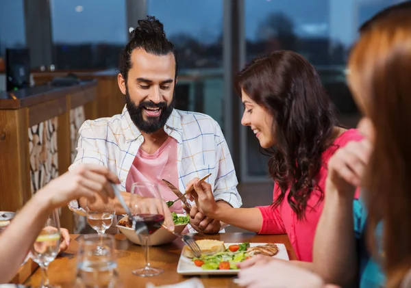 Amigos comer e degustação de alimentos no restaurante — Fotografia de Stock