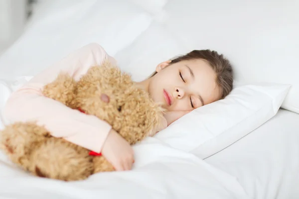 Mädchen schläft mit Teddybär im Bett zu Hause — Stockfoto