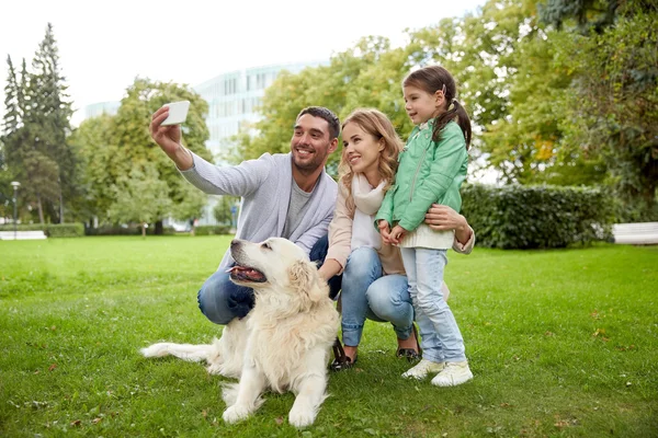 Gelukkige familie met hond selfie te nemen door smartphone — Stockfoto