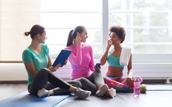 Glada kvinnor lyssnar på musik i gymmet — Stockfoto