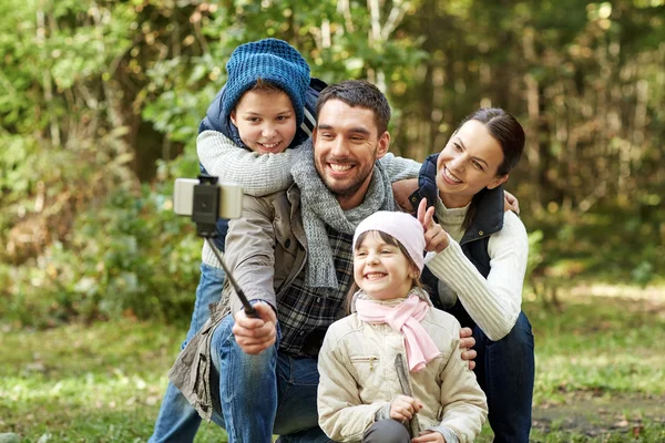 Happy family with smartphone selfie stick in woods — Stock Photo, Image