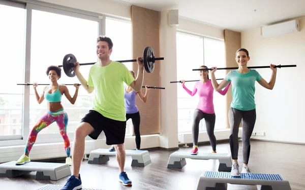 Gruppo di persone che si esercitano con il bilanciere in palestra — Foto Stock