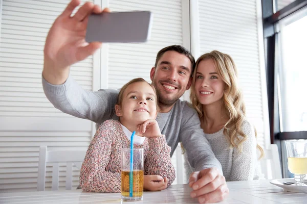 Família feliz tomando selfie no restaurante — Fotografia de Stock