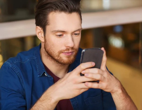 Hombre con mensaje de lectura de smartphone en el restaurante — Foto de Stock