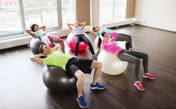 Szczęśliwi ludzie wyginanie mięśni brzucha na fitball — Zdjęcie stockowe