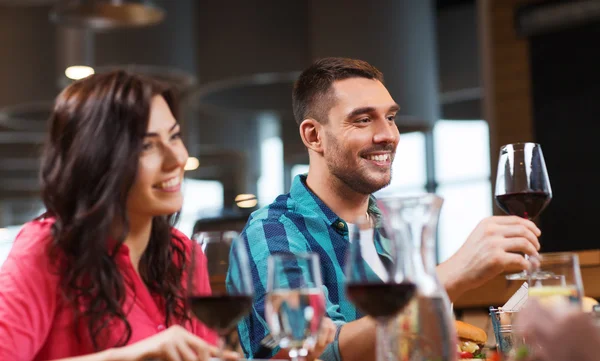 Friends clinking glasses of wine at restaurant — Stock Photo, Image