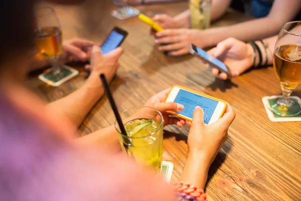 Close up of hands with smartphones at restaurant — Stock Photo, Image