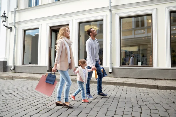 Gelukkig gezin met kind en boodschappentassen in stad — Stockfoto