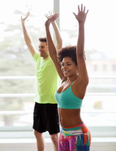 Groupe de personnes souriantes dansant en salle de gym ou studio — Photo