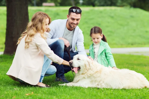 Gelukkig gezin met Labrador Retriever Dog in Park Stockfoto