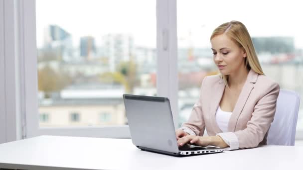 Joven mujer de negocios con computadora portátil escribiendo en la oficina — Vídeo de stock