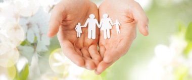 man hands holding paper cutout of family clipart
