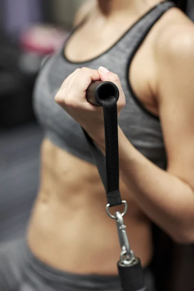 Close up of woman exercising on gym machine — Stock Photo, Image