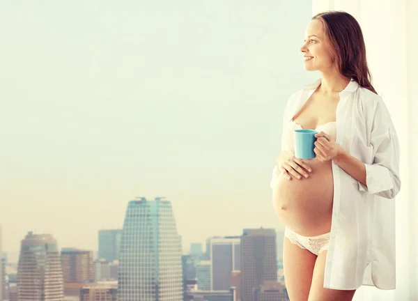 Felice donna incinta con tazza di tè a casa — Foto Stock