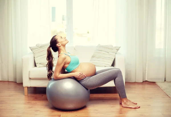 Happy pregnant woman exercising on fitball at home — Stock Photo, Image