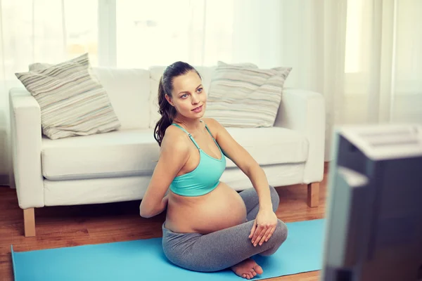 Femme enceinte heureuse exerçant à la maison — Photo