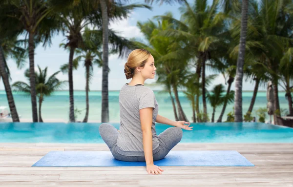 Mulher fazendo ioga em twist pose no tapete — Fotografia de Stock