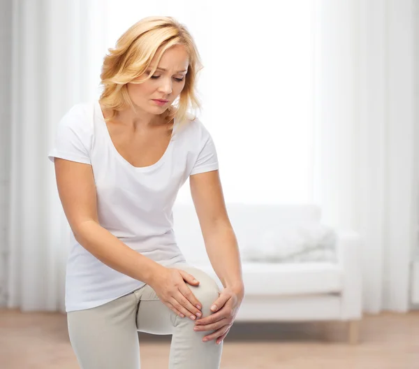 Unglückliche Frau leidet unter Schmerzen im Bein — Stockfoto