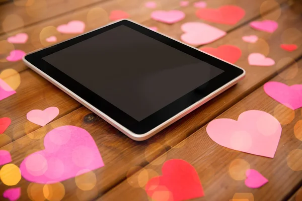 Close up of tablet pc and hearts on wood — Stock Photo, Image