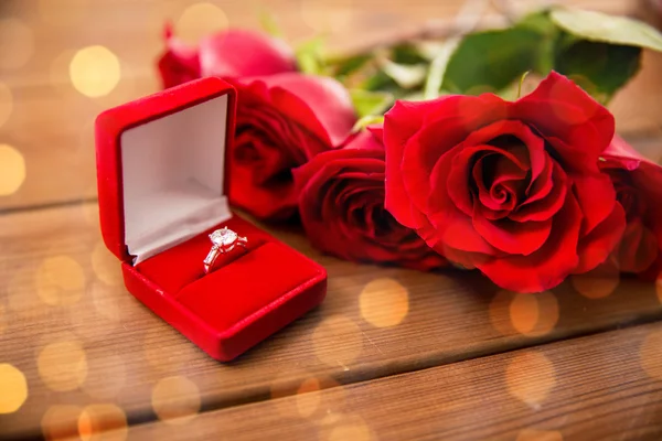 Nahaufnahme von Diamant-Verlobungsring und roten Rosen — Stockfoto