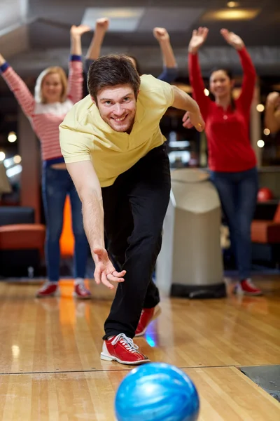 Счастливый молодой человек бросает мяч в боулинг-клуб — стоковое фото