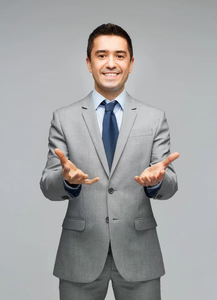 Felice uomo d'affari in giacca e cravatta che mostra palme vuote — Foto Stock