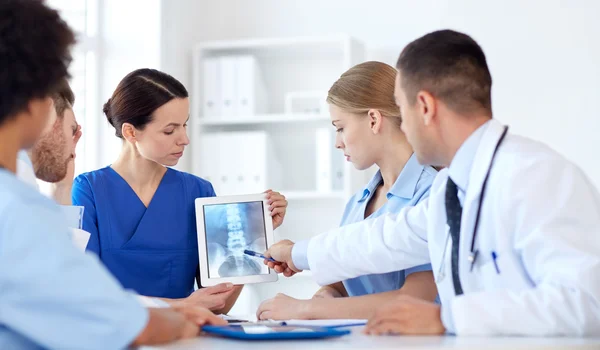 Grupo de médicos con rayos X en la tableta PC en la clínica — Foto de Stock