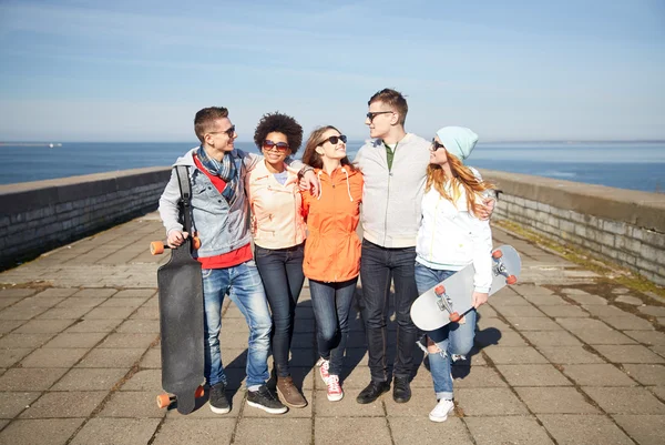 Happy teenage friends with longboards on street — Stock Photo, Image