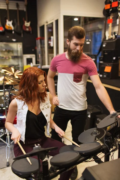 Man and woman with drum kit at music store — Stock Photo, Image