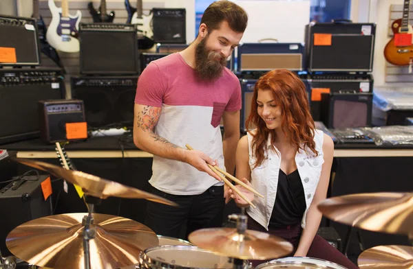 Hombre y mujer con kit de batería en la tienda de música —  Fotos de Stock