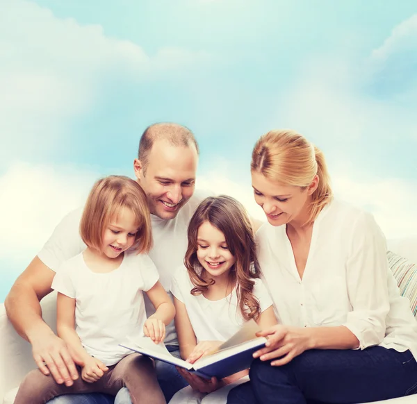 Família feliz com livro em casa — Fotografia de Stock