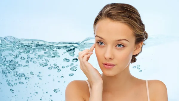 Mujer joven aplicando crema en su cara — Foto de Stock